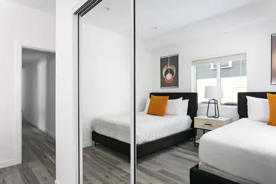 a bedroom with two beds and a mirror at Upscale LA Getaway Sleeps 8 with Free Parking in Los Angeles