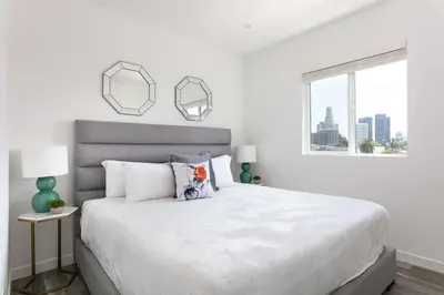 a white bedroom with a large bed and a window at Central 4BR Townhome Modern Perks in Los Angeles