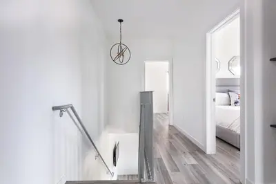 a white bedroom with a bed and a mirror at Central 4BR Townhome Modern Perks in Los Angeles