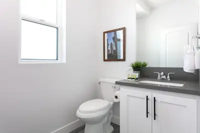 a white bathroom with a toilet and a sink at Spacious 4BR LA Getaway with Parking and Fast Wi-Fi in Los Angeles