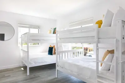 two white bunk beds in a white room at Spacious 4BR LA Getaway with Parking and Fast Wi-Fi in Los Angeles