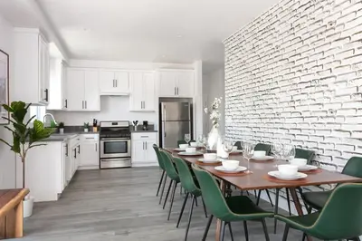 a kitchen with a wooden table and green chairs at Spacious 4BR LA Getaway with Parking and Fast Wi-Fi in Los Angeles