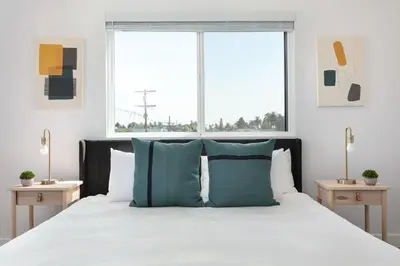 a bedroom with a large bed with blue pillows at Spacious 5BR Townhouse with Free Parking Included in Los Angeles