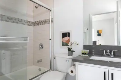 a bathroom with a shower and a toilet and a sink at Spacious 5BR Townhouse with Free Parking Included in Los Angeles