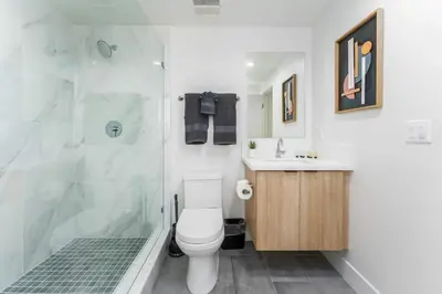 a bathroom with a shower and a toilet and a sink at Sunset Views from Private Rooftop in Luxe Townhome in Los Angeles
