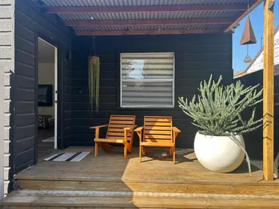 a blue house with two chairs and a potted plant at West LA Gem Comfort and Convenience in Los Angeles