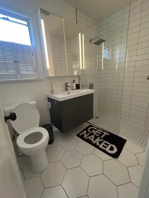 a bathroom with a toilet and a sink and a mirror at West LA Gem Comfort and Convenience in Los Angeles