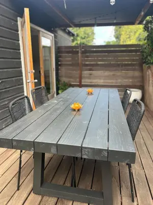 a wooden picnic table on a deck with chairs at West LA Gem Comfort and Convenience in Los Angeles