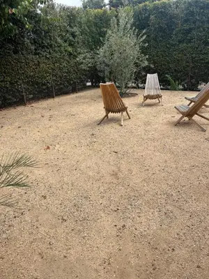 two wooden benches sitting in a dirt field at West LA Gem Comfort and Convenience in Los Angeles