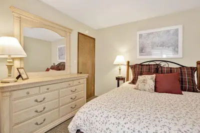 a bedroom with a bed with a dresser and a mirror at Slope Side Getaway at Big Bear - Central Duplex Retreat Chalet in Big Bear Lake