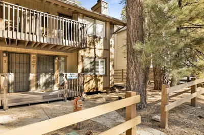 a house with a fence in front of it at Slope Side Getaway at Big Bear - Central Duplex Retreat Chalet in Big Bear Lake