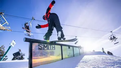 a person doing a trick on a snowboard on a rail at Slope Side Getaway at Big Bear - Central Duplex Retreat Chalet in Big Bear Lake