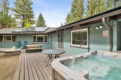 a house with a hot tub on a wooden deck at Arlberg Village Haus Game Room Walk to the Slopes in Big Bear Lake
