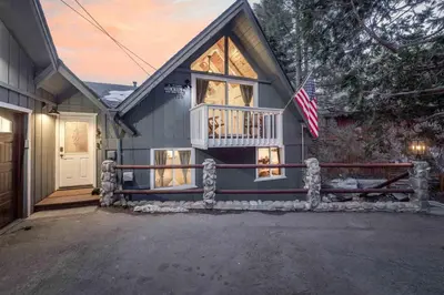 a house with a porch and an american flag at Cove Lakeside Jacuzzi, Central AC, Stunning View in Big Bear Lake