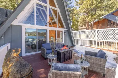 a screened in porch with furniture and a fireplace at Cove Lakeside Jacuzzi, Central AC, Stunning View in Big Bear Lake