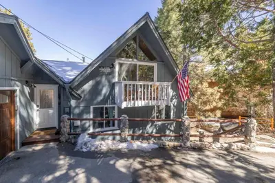 a house with a porch and an american flag at Cove Lakeside Jacuzzi, Central AC, Stunning View in Big Bear Lake