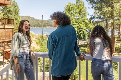 a man and two women standing on a railing at Cove Lakeside Jacuzzi, Central AC, Stunning View in Big Bear Lake