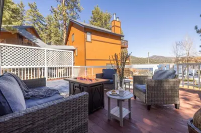 a patio with couches and chairs on a deck at Cove Lakeside Jacuzzi, Central AC, Stunning View in Big Bear Lake
