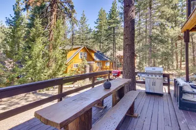a wooden bench sitting on the deck of a cabin at Golf and Swim! Pine Mtn Club Retreat with Game Area in Pine Mountain Club