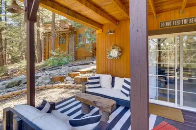 a porch with a couch and a bench on a house at Golf and Swim! Pine Mtn Club Retreat with Game Area in Pine Mountain Club