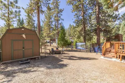 a large brown shed in a yard with trees at Dream Lake Cabin Spa, EV Charger, Gated, by lake! in Big Bear Lake