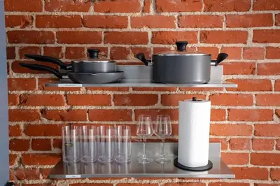 a brick wall with glasses and a pot and pans at Modern Bachelor in Hollywood in Los Angeles