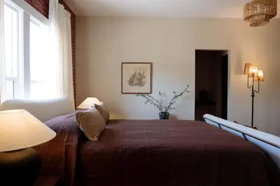 a bedroom with a bed with a red blanket and a window at The Hollywood Sign Lookout in Los Angeles