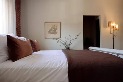 a bedroom with a bed with white sheets and brown pillows at The Hollywood Sign Lookout in Los Angeles