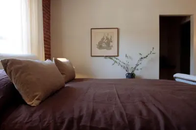 a bed with a brown blanket and pillows on it at The Hollywood Sign Lookout in Los Angeles