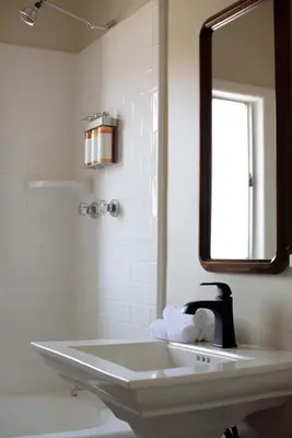 a white bathroom with a sink and a mirror at The Hollywood Sign Lookout in Los Angeles