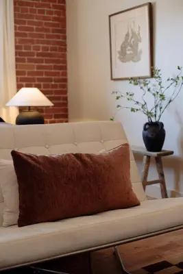 a white couch with a brown pillow sitting in a living room at The Hollywood Sign Lookout in Los Angeles
