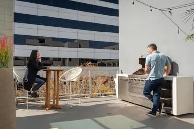 a man and a woman standing at a table in a kitchen at WEHO Place By Sunset Plaza in Los Angeles