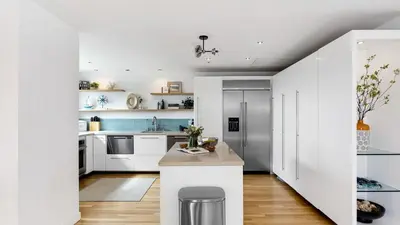 a kitchen with white cabinets and a white island at Walk to Manhattan Beach Pier Ocean Views Balcony Peloton Casa Del Mar by AvantStay in Manhattan Beach