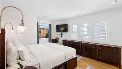 a white bedroom with a bed and windows at Walk to Manhattan Beach Pier Ocean Views Balcony Peloton Casa Del Mar by AvantStay in Manhattan Beach