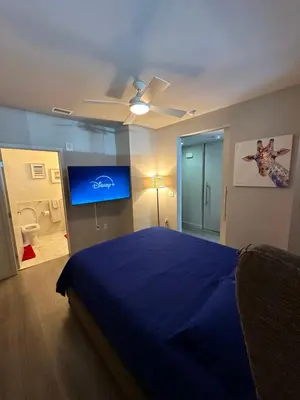 a bedroom with a blue bed and a flat screen tv at Luxury 2BR Apt with balcony!! in Los Angeles