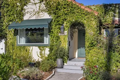 a house covered in ivy with a green door at The Whitley Heights Sweet Escape With Jacuzzi and parking in Los Angeles
