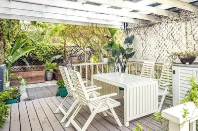 a white table and chairs on a wooden deck at The Whitley Heights Sweet Escape With Jacuzzi and parking in Los Angeles