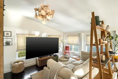 a living room with a large flat screen tv at The Whitley Heights Sweet Escape With Jacuzzi and parking in Los Angeles