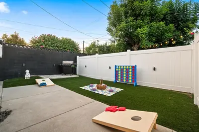 a backyard with a white fence and a play area at The Quirky Bloom-Whimsical Guest house in Upland