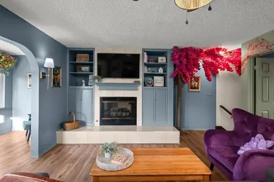 a living room with blue walls and a fireplace at The Quirky Bloom-Whimsical Guest house in Upland