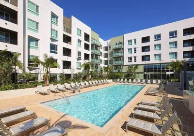 a swimming pool with lounge chairs and a building at Resort-Style APT with Pool, Gym & Parking 10min to Disneyland in Santa Ana