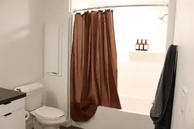 a bathroom with a toilet and a shower curtain at Resort-Style APT with Pool, Gym & Parking 10min to Disneyland in Santa Ana