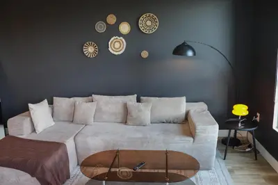 a living room with a white couch and clocks on the wall at Bright & Cozy Getaway with Pool Free Parking 10 mins Disneyland in Santa Ana