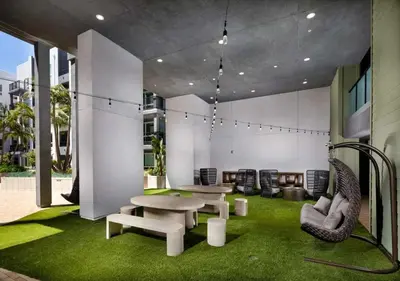 a room with two tables and chairs and grass at Luxe Deco Haven with Pool, Gym & Parking Close to Disneyland in Santa Ana