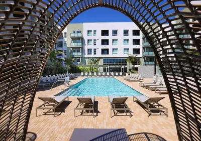 an archway with chairs and a pool and buildings at Luxe Deco Haven with Pool, Gym & Parking Close to Disneyland in Santa Ana