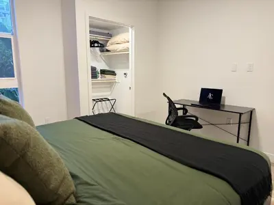 a bedroom with a bed and a desk and a closet at Luxe Deco Haven with Pool, Gym & Parking Close to Disneyland in Santa Ana