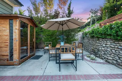 a patio with a table and an umbrella at Sea View, Sauna, Hot Tub, Beach Bikes, Stream in Ventura
