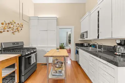 a kitchen with white cabinets and a black stove at Ocean View, Hot Tub, Sauna, Beach Bikes in Ventura