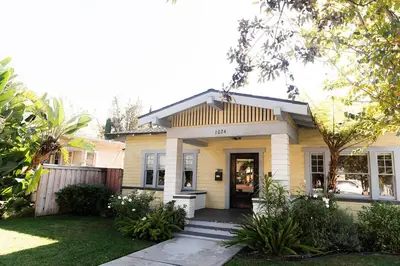 a yellow house with a front door and a porch at Historic craftsman sleeps 9 3br2.5ba Disney 1mi in Anaheim