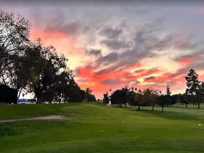 a sunset over a golf course with trees and a field at Historic craftsman sleeps 9 3br2.5ba Disney 1mi in Anaheim